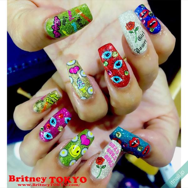 [BritneyTOKYO/カラフル/個性派/アメリカン/ポップ/ミディアム/スクエアオフ/ワンカラー/ラメ/ピンク/イエロー/黄色/グリーン/緑/ブルー/水色/ハート/ニコちゃん/フラワー/花柄/バラ/ローズ]のタグが付いたネイルデザイン