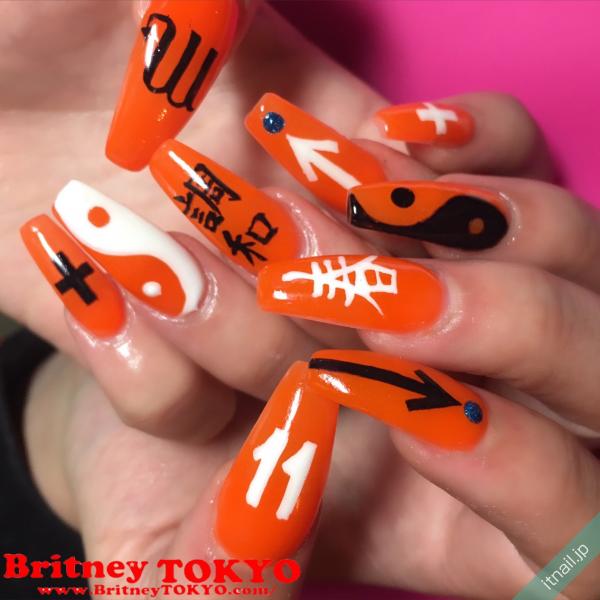 [BritneyTOKYO/カラフル/個性派/アメリカン/ポップ/ロング/スクエアオフ/ワンカラー/オレンジ/ホワイト/白/漢字/数字/クロス/十字架]のタグが付いたネイルデザイン