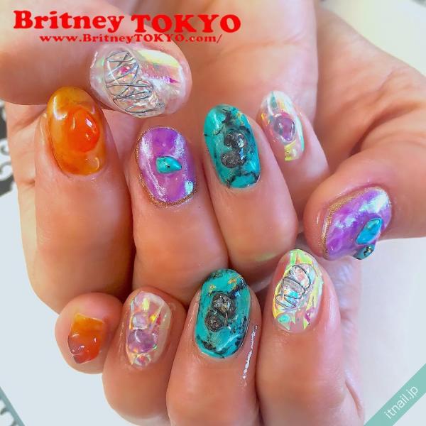 [BritneyTOKYO/カラフル/個性派/ショート/オーバル/オーロラ/フィルム/パープル/紫/グリーン/緑/オレンジ/天然石]のタグが付いたネイルデザイン